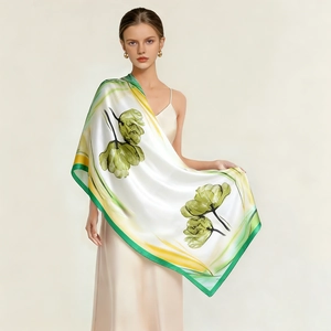 Detailed view of large silk scarf featuring green tulip print on smooth satin fabric