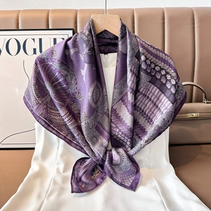 Detail of luxury silk square scarf with purple vintage floral and heraldic patterns