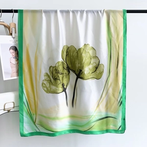 Detail view of silky beach scarf with watercolor green tulip prints and vibrant borders