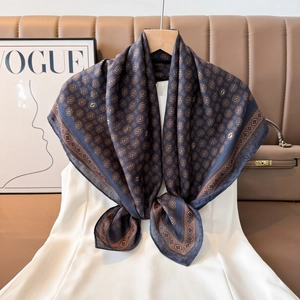 Vintage navy blue silk scarf with paisley patterns draped against a luxury background