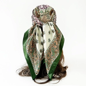 Close-up of green paisley satin silk scarf showing smooth texture and floral pattern