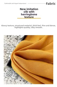 Detail of ginger yellow herringbone silk scarf showing thick smooth texture and luxury gloss