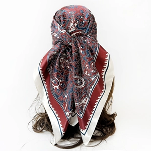 Detail of red and blue paisley silk scarf styled as an elegant headwrap for women