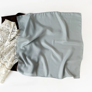 Detailed close-up of light blue square scarf featuring premium herringbone cotton linen texture