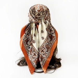 Detail of bohemian orange satin scarf showing classic paisley print and silky texture