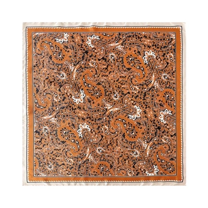 Macro detail of high-quality orange silk scarf with intricate vintage paisley patterns