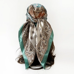 Detailed view of paisley patterned satin headscarf styled on a mannequin head model