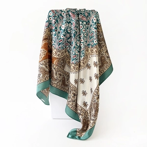 Detail view of smooth satin scarf with paisley floral pattern and green border finish