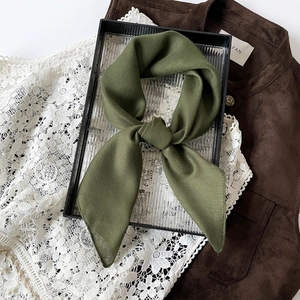 Detailed view of dark green herringbone texture cotton linen scarf on glass tray
