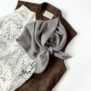 Detail of mauve herringbone silk scarf showing refined texture and knotted styling