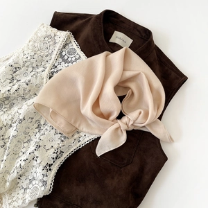 Detail of soft silk headscarf paired with brown suede vest and white lace top