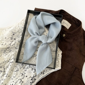 Detail of light blue hijab scarf featuring a refined herringbone texture and knotted style
