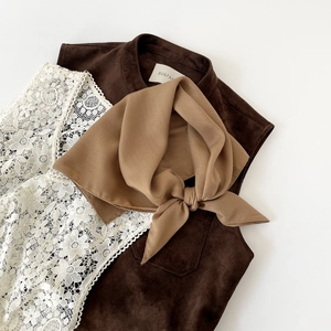 Detailed view of dark brown velvet vest paired with white floral lace top and scarf