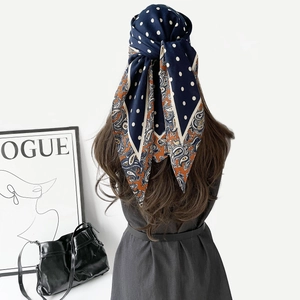 Vue arrière d'un foulard en soie bleu marine à pois blancs et motif paisley en turban chic