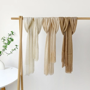 Close-up of lightweight glitter mesh scarves with elegant tassels in neutral colors