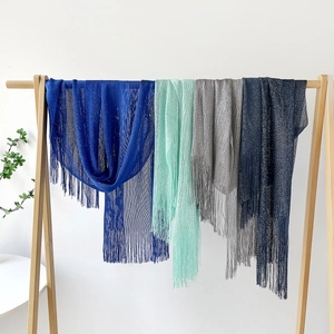 Close-up of lightweight metallic mesh shawls with long fringes in multiple colors
