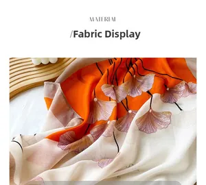 Détail du tissu du foulard dégradé avec motifs de feuilles de ginkgo orange