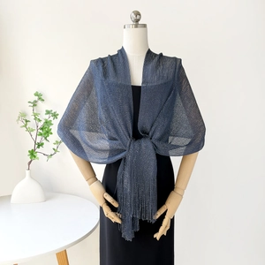 Detail of dark blue metallic shawl with fringe tassels over a black dress