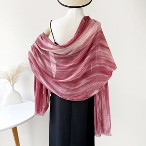 Detail of red gradient cotton shawl with subtle pleated texture on a white mannequin