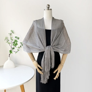 Elegant silver metallic mesh shawl with long fringe tassels tied over a black dress
