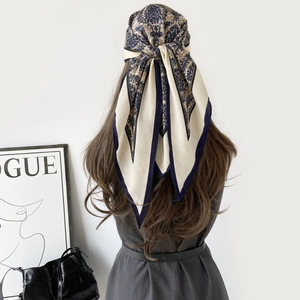 Détail d'un foulard en soie baroque porté comme élégant accessoire de coiffure