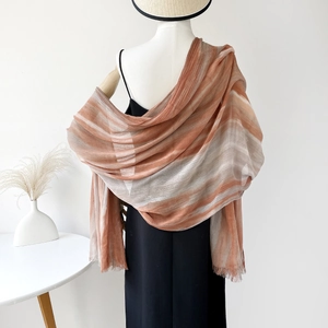 Detail of lightweight ombre shawl with orange and grey gradients and raw fringe edges
