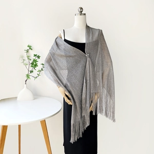 Detail of silver metallic mesh shawl featuring long tassels for evening party dresses