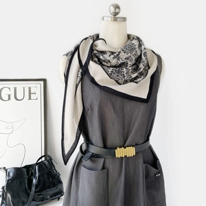 Détail d'un foulard en soie à imprimé floral vintage avec bordure noire à la taille