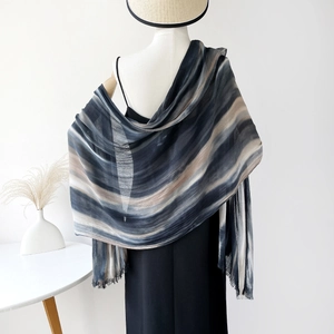 Detail of navy blue and grey gradient striped shawl with delicate fringe on mannequin