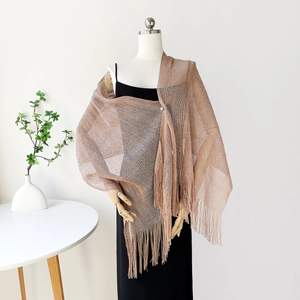 Close-up of champagne gold metallic shawl with fringe on a mannequin for evening wear