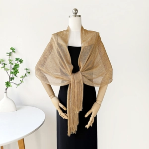 Detailed view of gold metallic mesh shawl with fringe on a dress form mannequin
