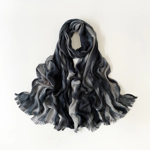 Flat lay of gradient black and grey beach scarf with delicate fringe edges