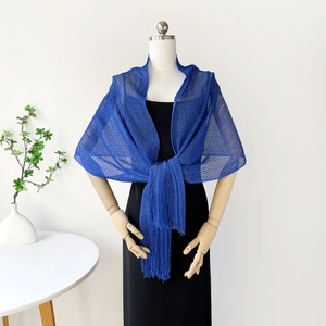 Detail of royal blue knit shawl with metallic yarn, hollow mesh texture and long tassels