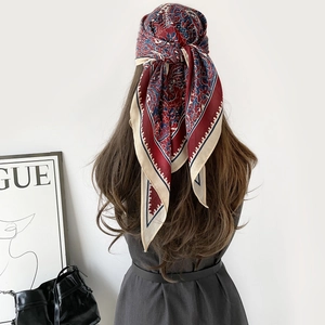 Détail d'un foulard en soie rétro à motif cachemire porté en bandeau élégant
