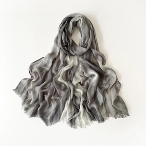 Close-up of gray and white gradient scarf with delicate fringe edges and soft texture