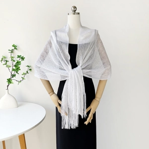 Detailed view of silver metallic knit shawl featuring long tassels and mesh texture