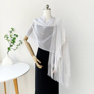 Detailed close-up of white glitter shawl featuring long fringe and metallic mesh texture