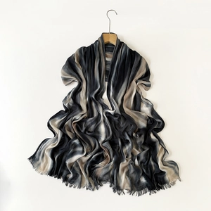 Detail of pleated gradient scarf with fringe trim in black grey and beige shades