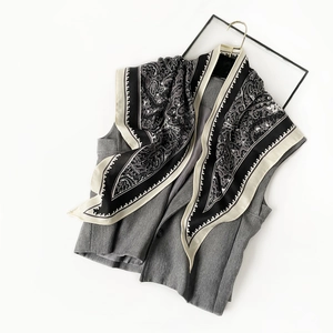 Détail d'un gilet gris sans manches avec un foulard en soie au motif cachemire