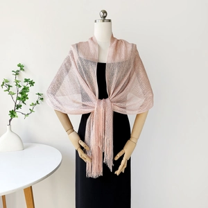 Close-up of rose gold sparkling knit shawl featuring delicate fringe trim details