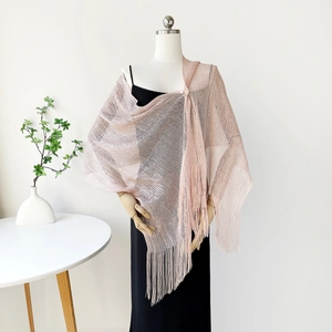 Detail view of champagne sparkling knit shawl with elegant fringe tassels on a mannequin