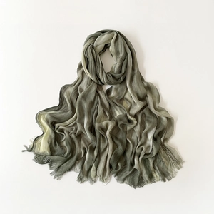 Detailed macro view of olive green gradient scarf fabric texture and tassel fringe details