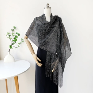 Detail of black metallic fringe shawl showing fine mesh weave and silver glitter texture