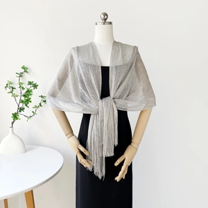 Detailed texture of silver lurex knit shawl with elegant fringe for evening wear