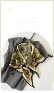 Close-up of vintage floral triangle scarf with olive green and yellow silk-like texture