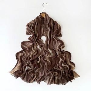 Detailed view of brown gradient pleated scarf with elegant fringe trim and soft fabric