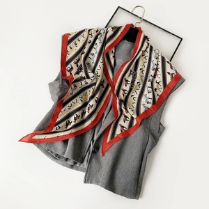 Detail of grey vest paired with a vintage red-bordered horse pattern silk scarf