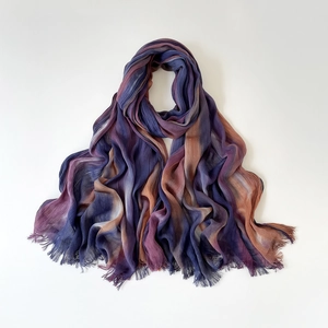 Detailed macro view of gradient purple and terracotta viscose scarf with fringed edges
