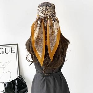 Détail d'un foulard floral à chevrons porté comme bandeau sur un fond de mode élégant