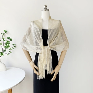 Detail view of champagne gold glitter tassel shawl with elegant mesh knit pattern